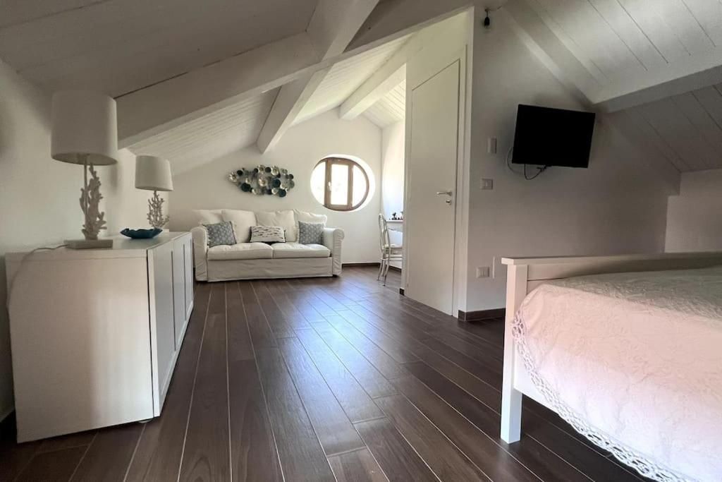 Ein Schlafzimmer mit einem Bett, einem Schreibtisch, einem Sessel, einer Couch und einem Fernseher.