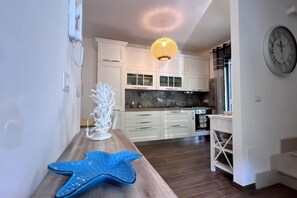 Eine moderne Küche mit weißen Schränken, einer Holz Arbeitsplatte und einem dekorativen Seestern.