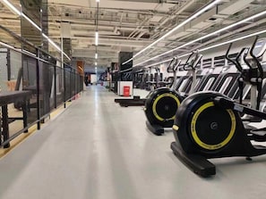 Ein Fitnessstudio mit Laufbändern, Trainingsgeräten und einem sauberen, gut beleuchteten Raum.
