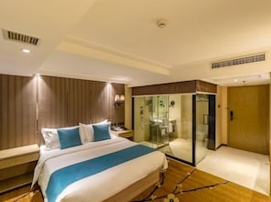 Ein Hotelzimmer mit Bett, Duschkabine und einer Tür zu einem Badezimmer.