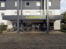Un hotel B&B con fachada moderna, zona de estar al aire libre y entrada despejada.