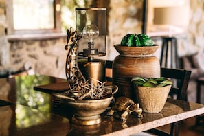Een tafel met een messing lamp, een cactus en een terracotta pot.