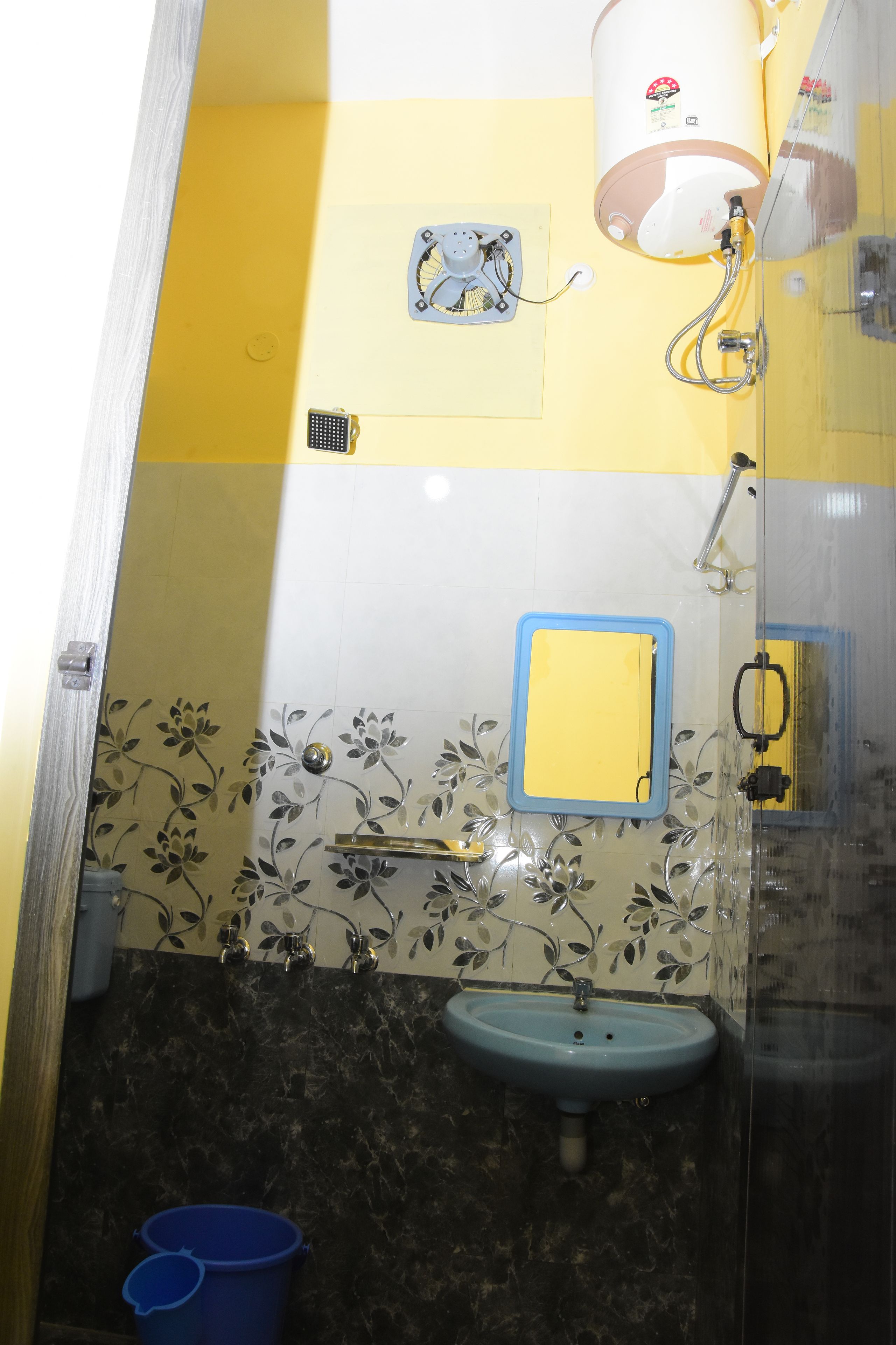 Un baño con un lavabo azul, un espejo, una ducha y un inodoro.