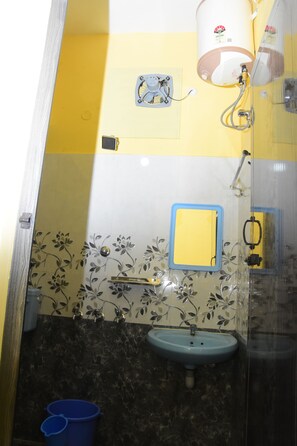Ein Badezimmer mit blauem Waschbecken, einem Spiegel, einer Dusche und einer Toilette.