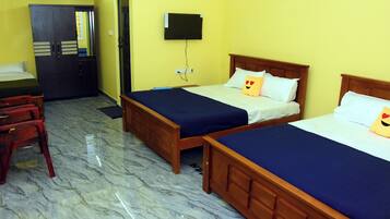 A hotel room with two beds, a desk, a chair, and a television on the wall.