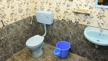 Une salle de bain avec des toilettes, un lavabo et une douche.