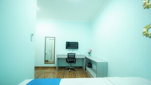 A room with a bed, a desk, a chair, a television, and a mirror. - Rehat at Zeva Guest House (Bandung)