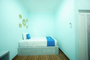 A bedroom with a bed, a wall-mounted thermostat, and a door. - Rehat at Zeva Guest House (Bandung)