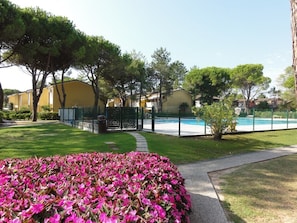 A residential area with a swimming pool, a pathway, and a flower bed. - Accommodation in Residence With Pool and Garden (San Michele al Tagliamento)