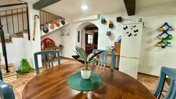 A dining area with a wooden table, chairs, and a potted plant.