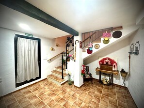 A staircase with a handrail, a door labeled 'SALIDA,' and a wall-mounted basket with flowers.