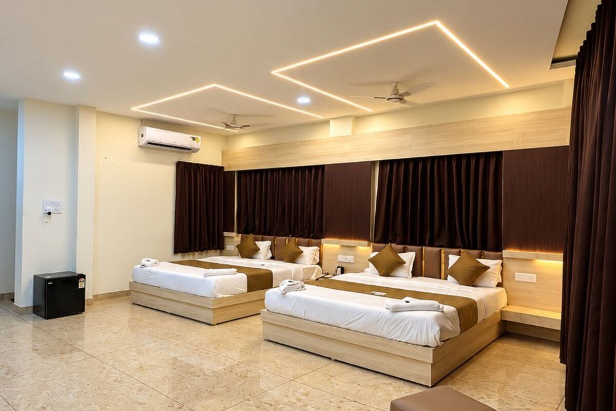Una habitación de hotel con una cama grande, una mesita de noche, un armario y aire acondicionado, además de un ventilador de techo.