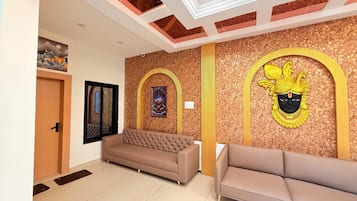 Un interior moderno con un sofá, paneles decorativos en la pared e iluminación empotrada en el techo.