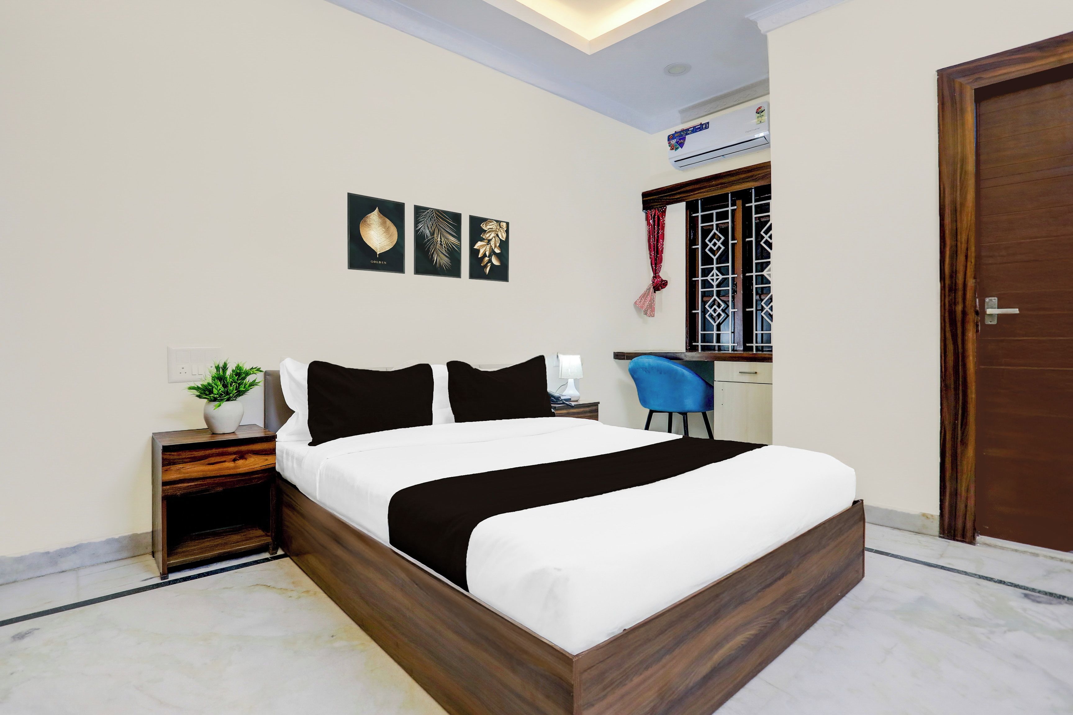 A neatly arranged bedroom with a bed, bedside table, and a small desk area.