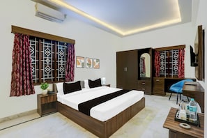 A hotel room with a bed, a desk, a wardrobe, and a television. - Townhouse Madiwala Lake Park (Bengaluru)