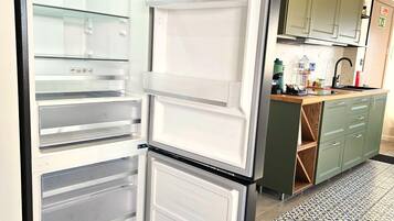 Una cucina con un frigorifero a doppia porta, un lavello e un pavimento decorato.