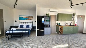 A compact room with a bed, a kitchenette, and a bathroom. - Modern Blue Horizon Studio In Blue Grotto (Qrendi)