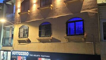 Um edifício com uma placa indicando 'SottoZero The Gelato Factory' à noite.