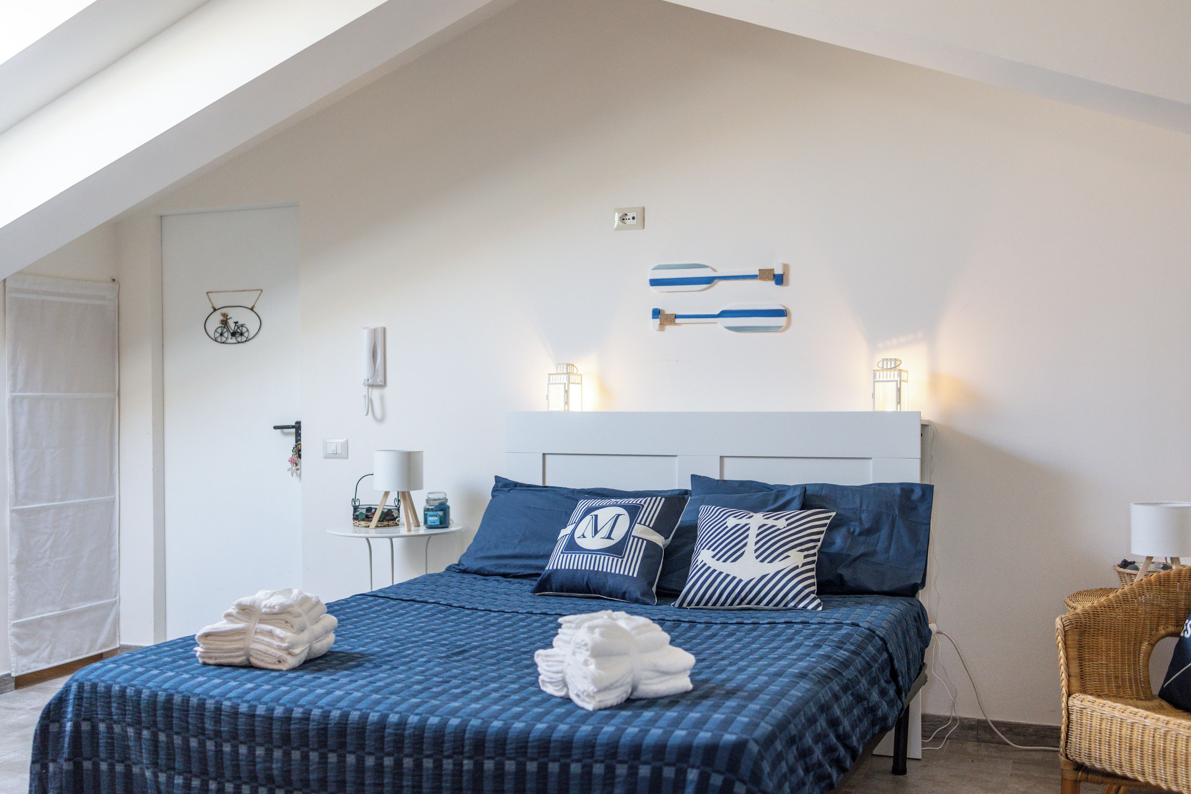 Ein Schlafzimmer mit einem Bett, Kissen, einem Nachttisch und einer Lampe.