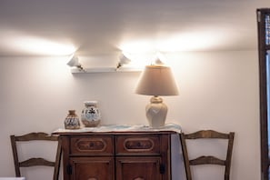 Eine Holzkommode mit Schubladen, eine Tischlampe und zwei dekorative Vasen darauf.