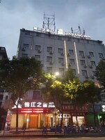 Un edificio de varios pisos con señalización que indica 'JINJIA ZHOU' y 'Estilo JINJIA ZHOU'.