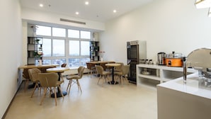 Una cocina moderna con un amplio ventanal, un refrigerador, una estufa y un lavamanos.