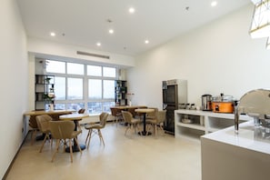 Una cocina moderna con un amplio ventanal, un refrigerador, una estufa y un lavamanos.