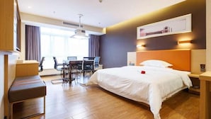 Una habitación de hotel con una cama, un escritorio y una silla.