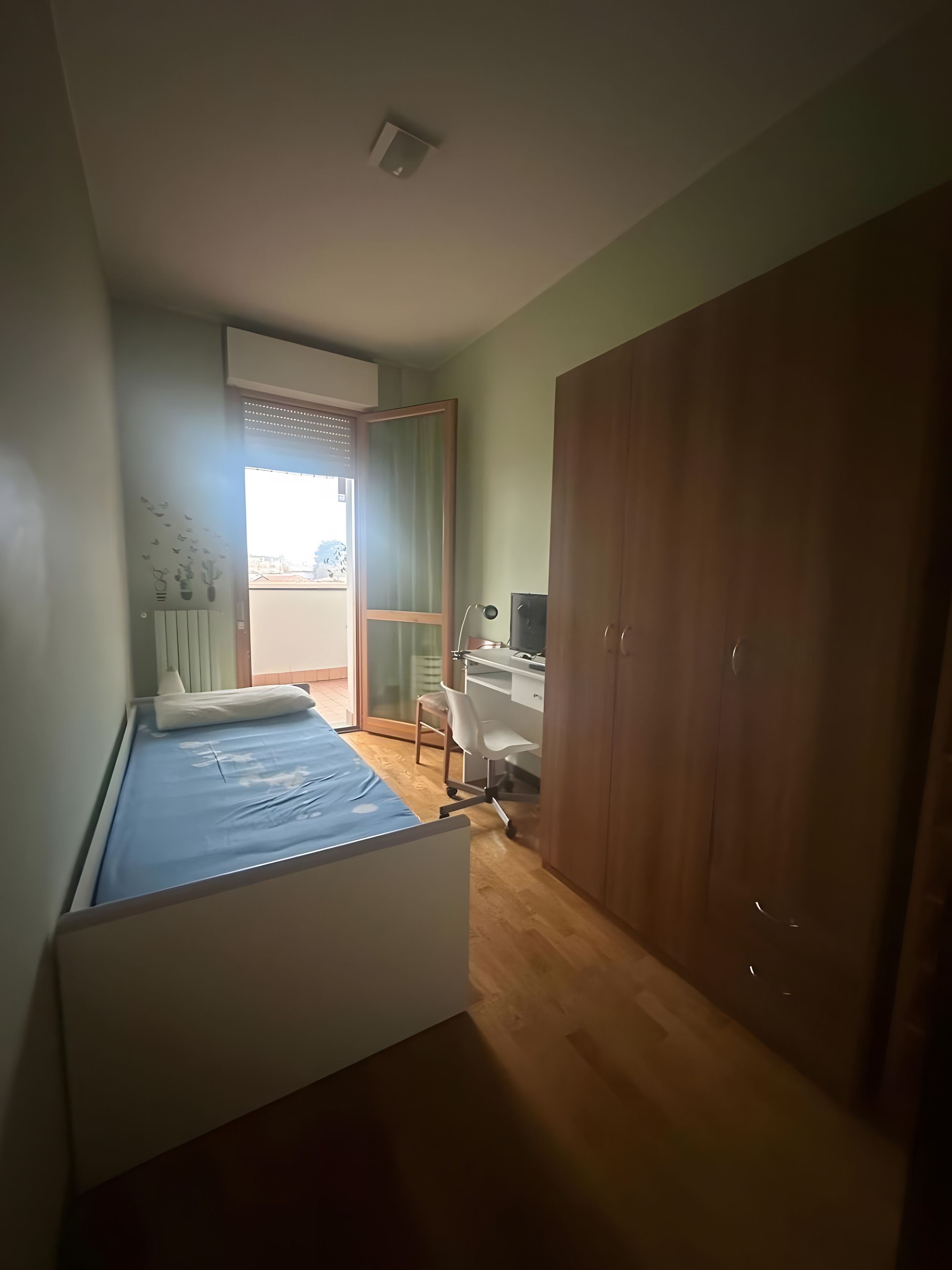 Quarto com cama, escrivaninha e guarda-roupa.