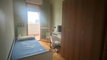 Quarto com cama, escrivaninha e guarda-roupa.