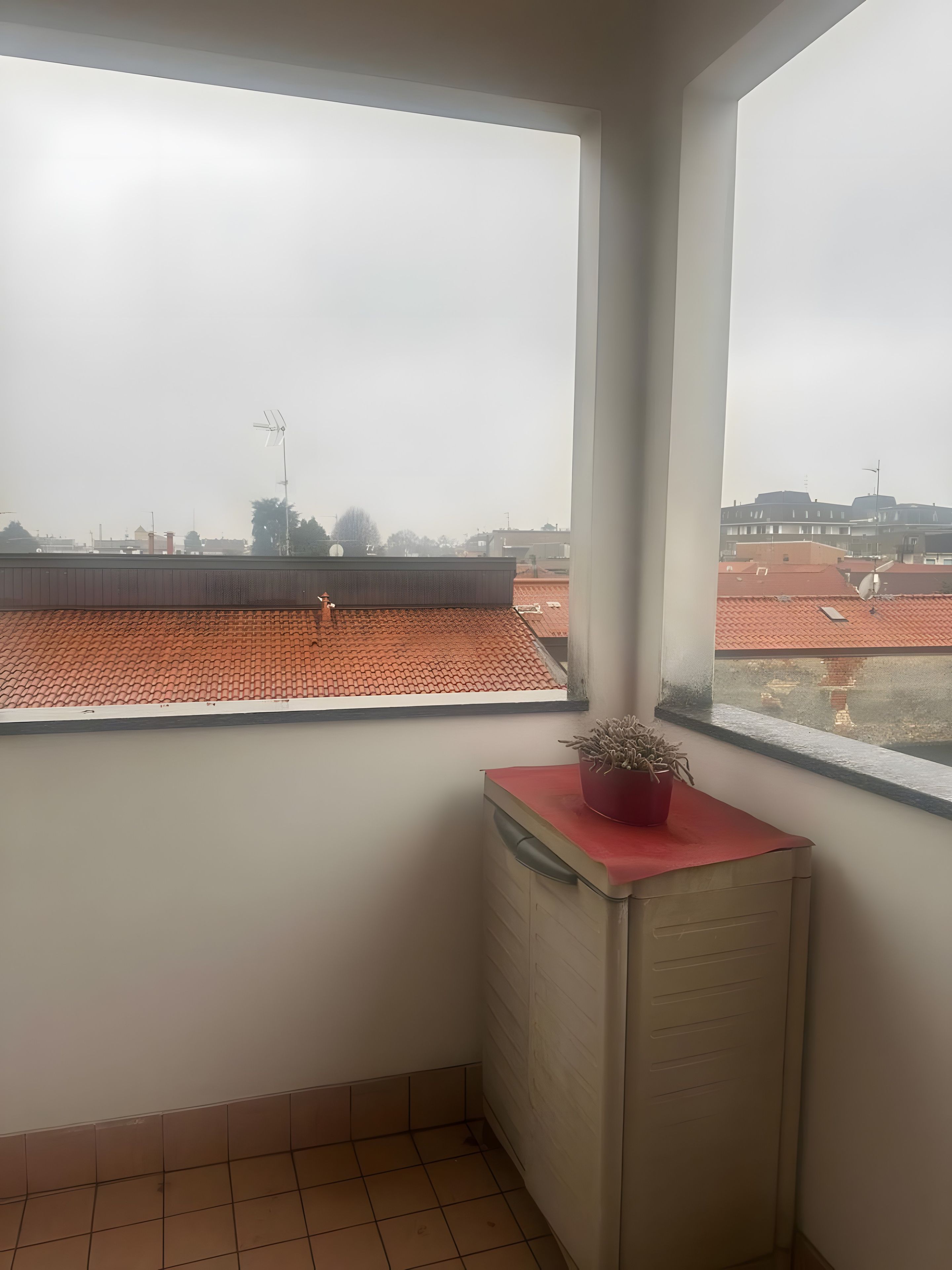 Ein Eckzimmer mit Blick auf eine Stadtlandschaft durch ein Fenster.