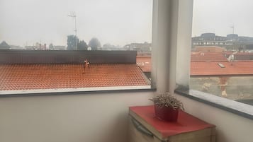 Una camera d'angolo con vista sulla città attraverso una finestra.