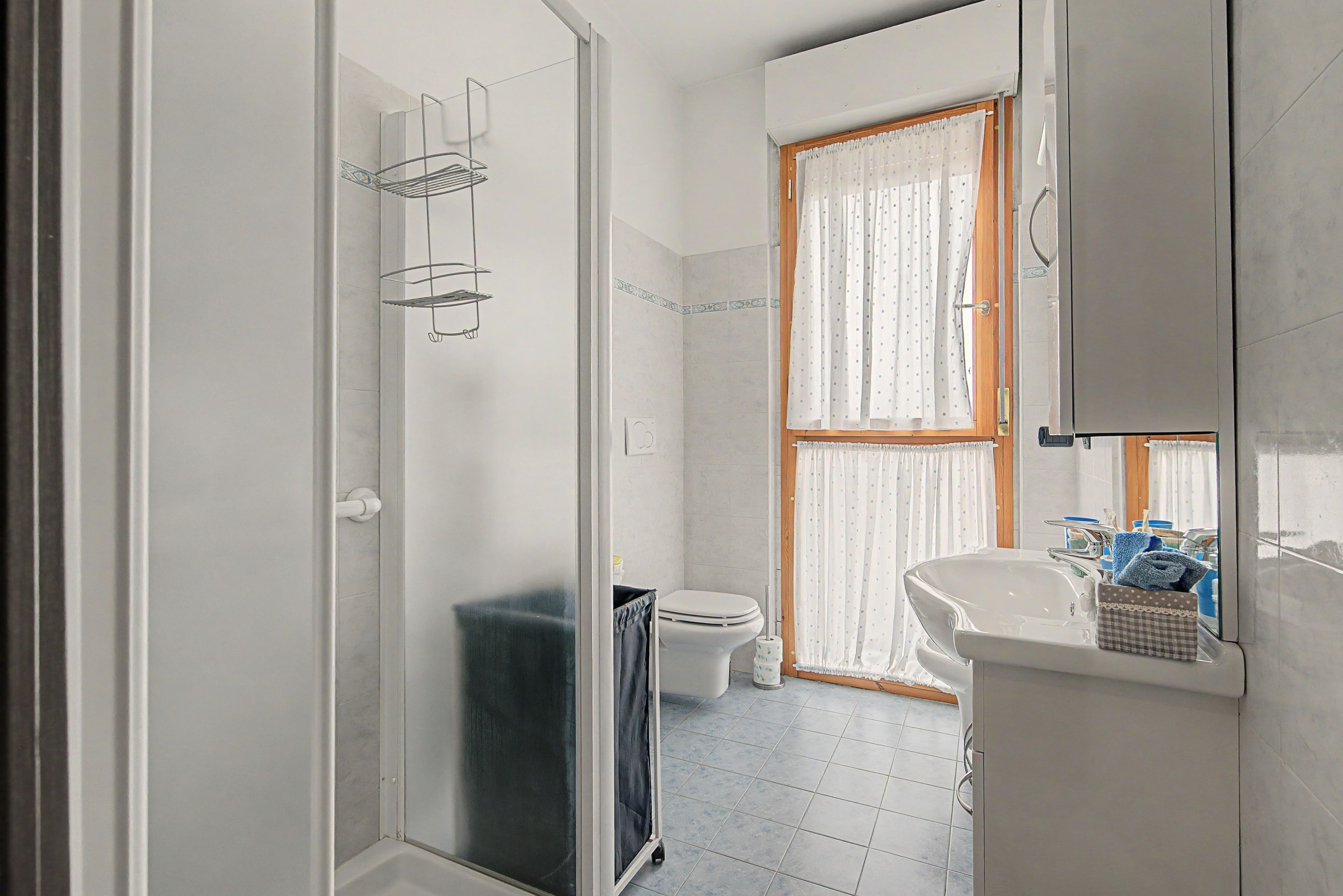Une salle de bain avec douche, toilettes et lavabo.