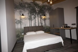 A bedroom with a bed, a desk, and a wall mural. - Koru Otel & Restaurant (Artvin)