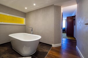 Une salle de bain moderne avec une baignoire sur pieds, un porte-serviettes et un espace douche bien délimité.