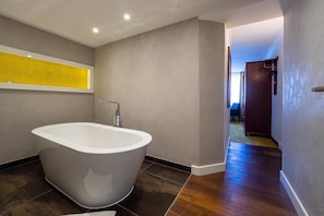 Un baño moderno con una bañera independiente, un perchero y una zona de ducha visible.