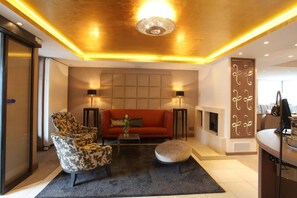 Una sala de estar moderna con un sofá, sillones, una mesa de centro y una chimenea.