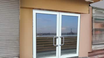 A double door with glass panels and metal handles, set against a beige wall.