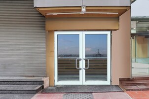 Entrada con doble puerta y un toldo metálico.