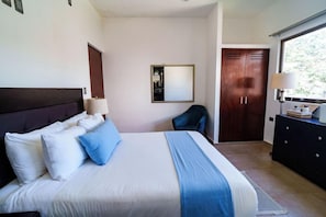 Una camera d'albergo con un letto, una scrivania, una sedia, un armadio e una finestra.
