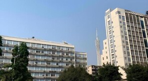 A multi-story building with a modern architectural design, featuring a series of balconies and a prominent central tower. - Ying Feng Yuan Hotel (Guangzhou)