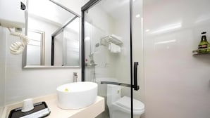 A modern bathroom with a glass-enclosed shower, a white sink, and a mirror. - Ying Feng Yuan Hotel (Guangzhou)