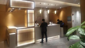 A reception area with a modern design, featuring a reception desk, a waiting area, and a reception counter. - Ying Feng Yuan Hotel (Guangzhou)
