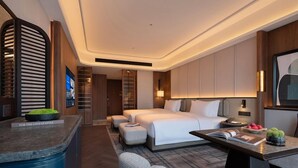 A modern hotel room with a large bed, a desk, and a seating area. - Wyndham Changsha Yanghu (Changsha)