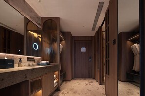 Un baño moderno con encimera de mármol, un espejo grande y muebles de madera.
