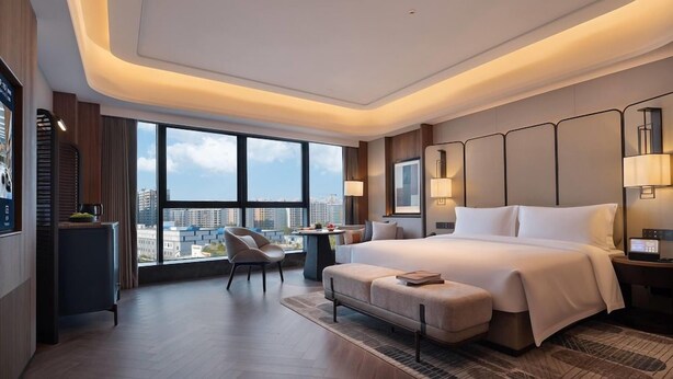 A modern hotel room with a large bed, a desk, a chair, and a view of the city. - Wyndham Changsha Yanghu (Changsha)