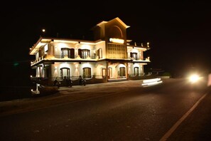 A multi-story building with a prominent entrance and a balcony on the upper floor. - Mastiff Hotel Palampur (Palampur)
