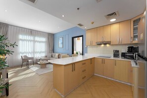 Una cocina moderna con armarios de madera, encimera de mármol y horno empotrado.