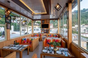 Un restaurant amb interiors de fusta, grans finestres i vistes a la ciutat.
