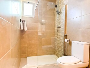 A modern bathroom with a glass-enclosed shower, a toilet, and a towel rack. - Bia Serviced Apartments & Bia D'olaf (Sal)